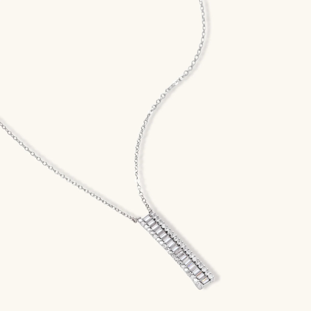 White gold plated necklace and hoop earrings featuring geometric ladder-pattern clear zirconia stones on neutral background.