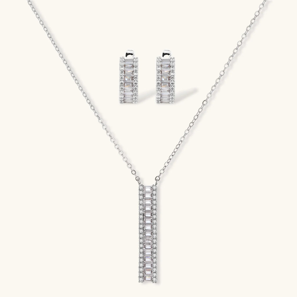 White gold plated necklace and hoop earrings featuring geometric ladder-pattern clear zirconia stones on neutral background.