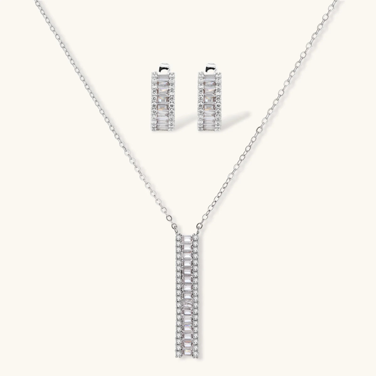 White gold plated necklace and hoop earrings featuring geometric ladder-pattern clear zirconia stones on neutral background.