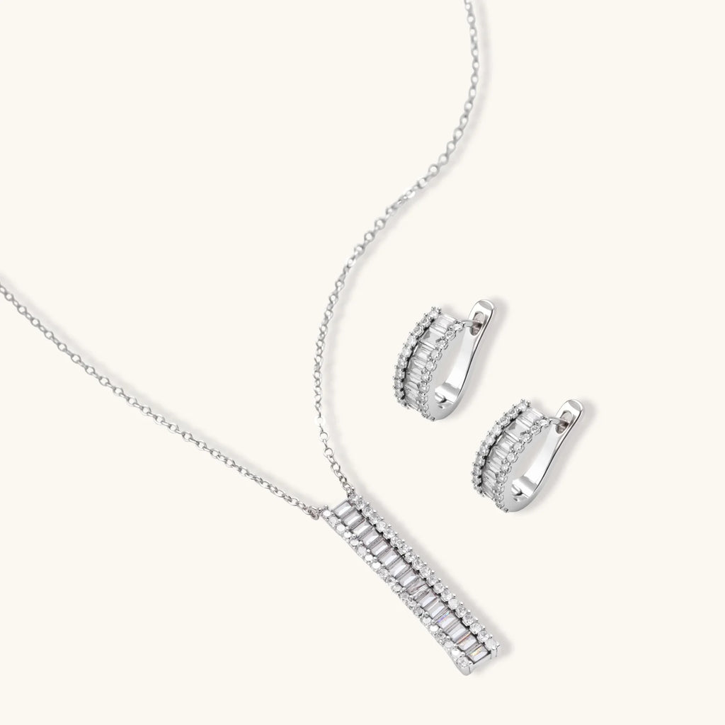 White gold plated necklace and hoop earrings featuring geometric ladder-pattern clear zirconia stones on neutral background.