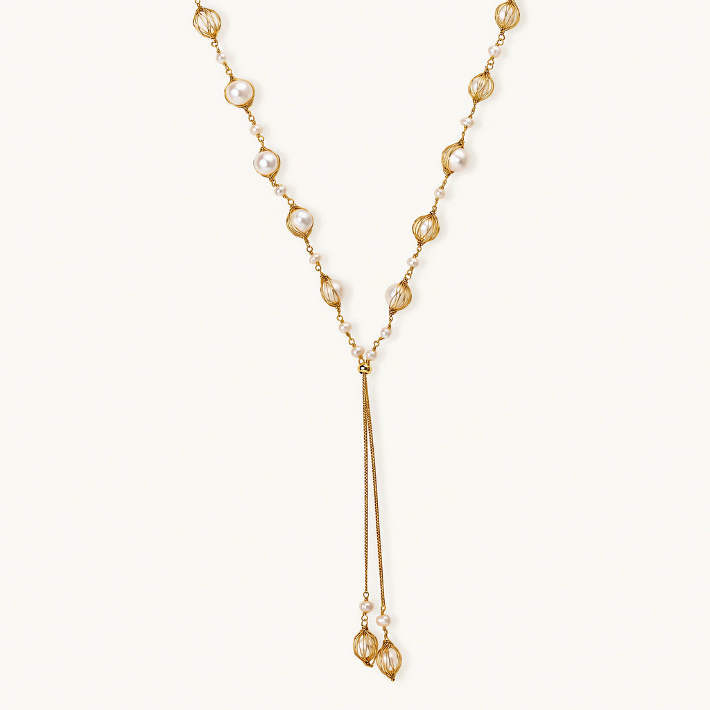 Adjustable gold lariat necklace with freshwater pearls nested in delicate cage settings and Y-shaped tassel drop